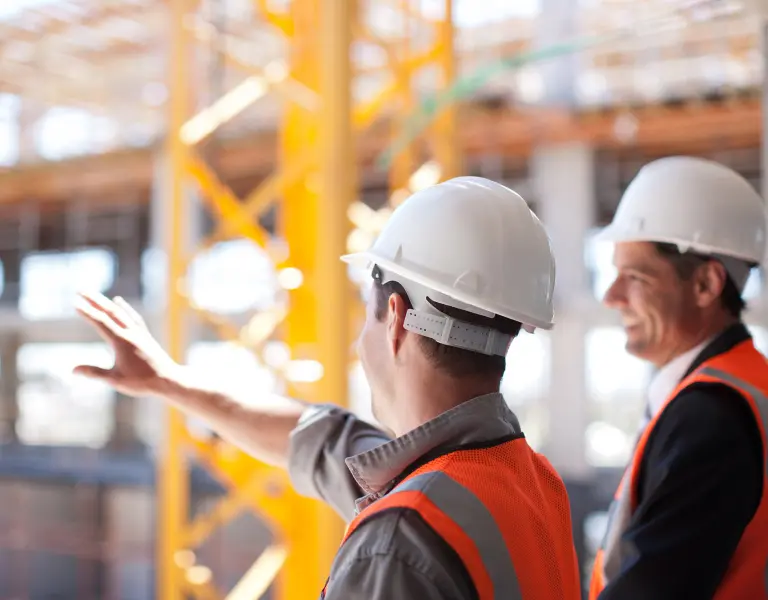 Bauarbeiter bespricht die Baustelle mit Bauherren