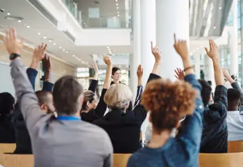 Menschengruppe die aufzeigt um Frage zu stellen