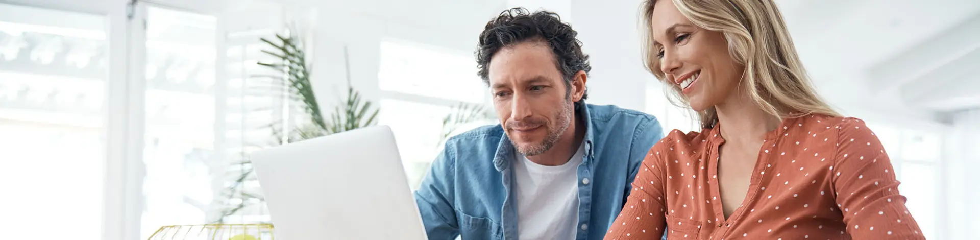 mann-und-frau-sitzen-lachend-vorm-laptop