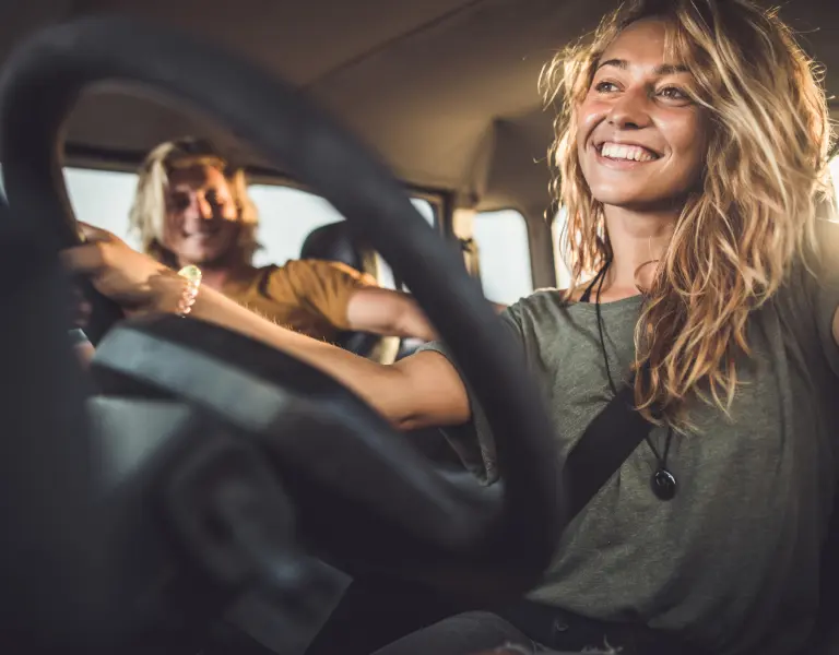 junge Frau glücklich im Auto