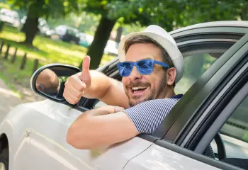 Mann sitzt glücklich im Auto