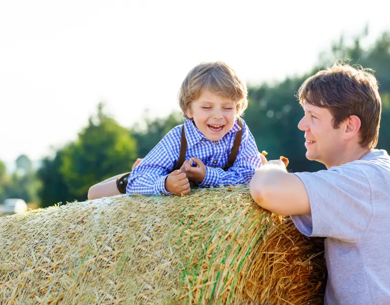 Green Care - Kind und Mann bei Heuballen