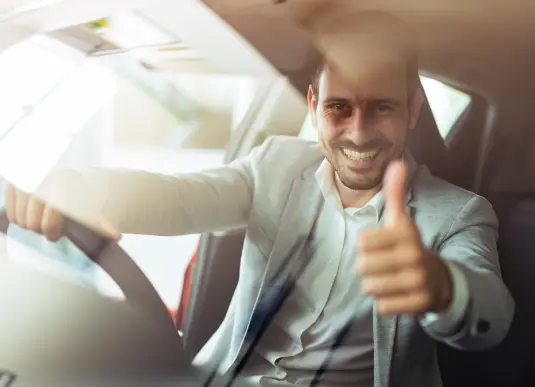 Mann in Auto zeigt Daumen hoch