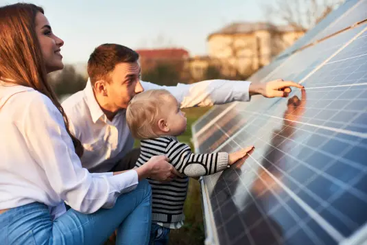 junge Familie begutachtet Photovoltaikanlage