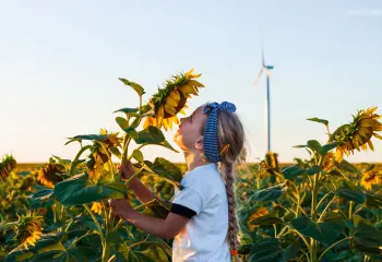Kleines Mädchen riecht an einer Sonnenblume