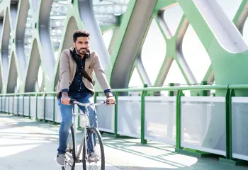 Mann mit Fahrrad auf einer Brücke