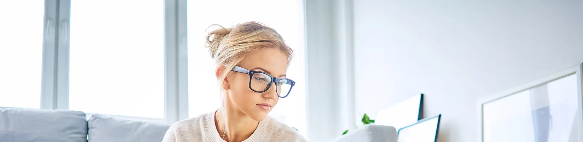 junge Frau arbeitet und sitzt vor Laptop
