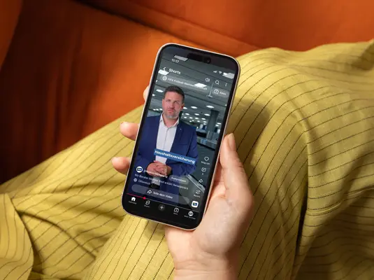 Frau hält Handy und sieht sich Video an