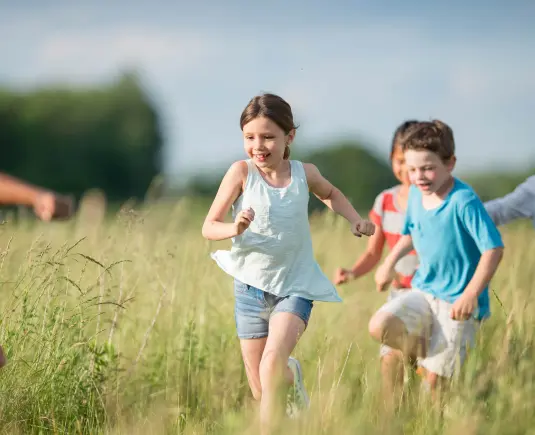 Kinder laufen über Wiese