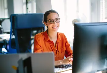 Frau vorm Computer am Arbeitsplatz