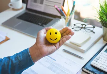 Hand die ein Smiley hält