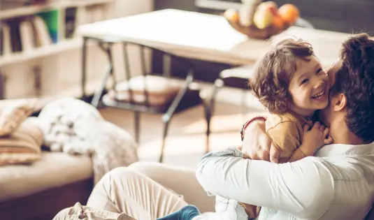 Vater mit Kind kuscheln auf Sofa