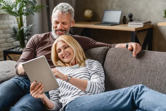 älteres Paar sitzt auf Sofa